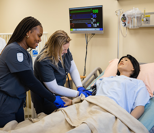 Nursing student around a mannequin