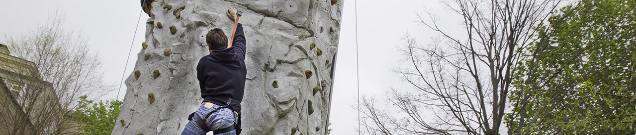 Student climbing a rock wall