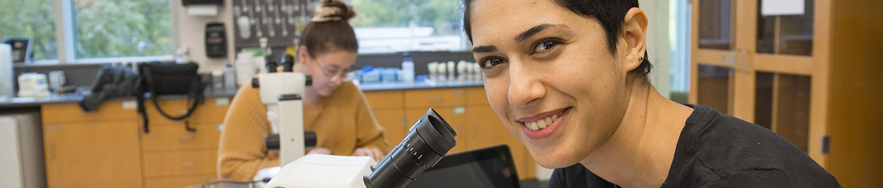 Student looking up from her microscope