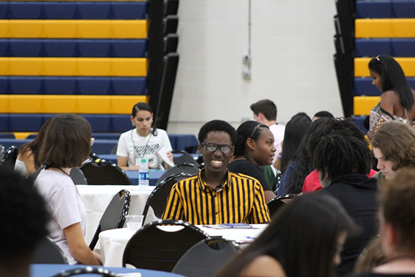 students at tables talking to each other